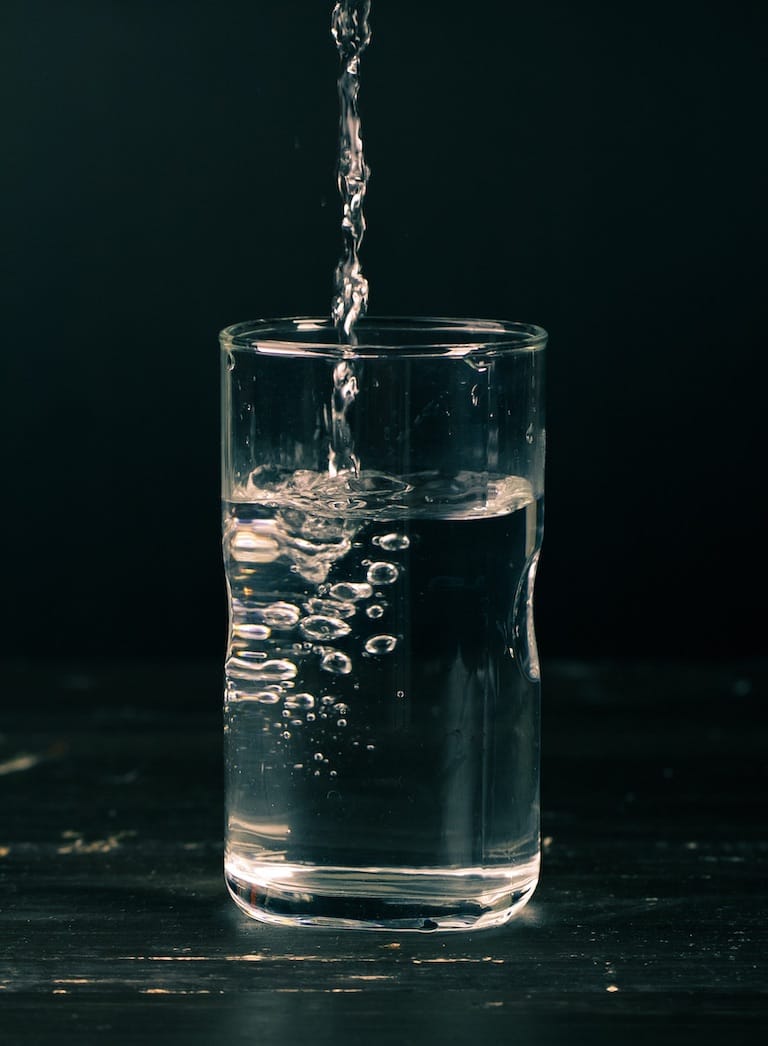 Wasser in ein Glas schütten
